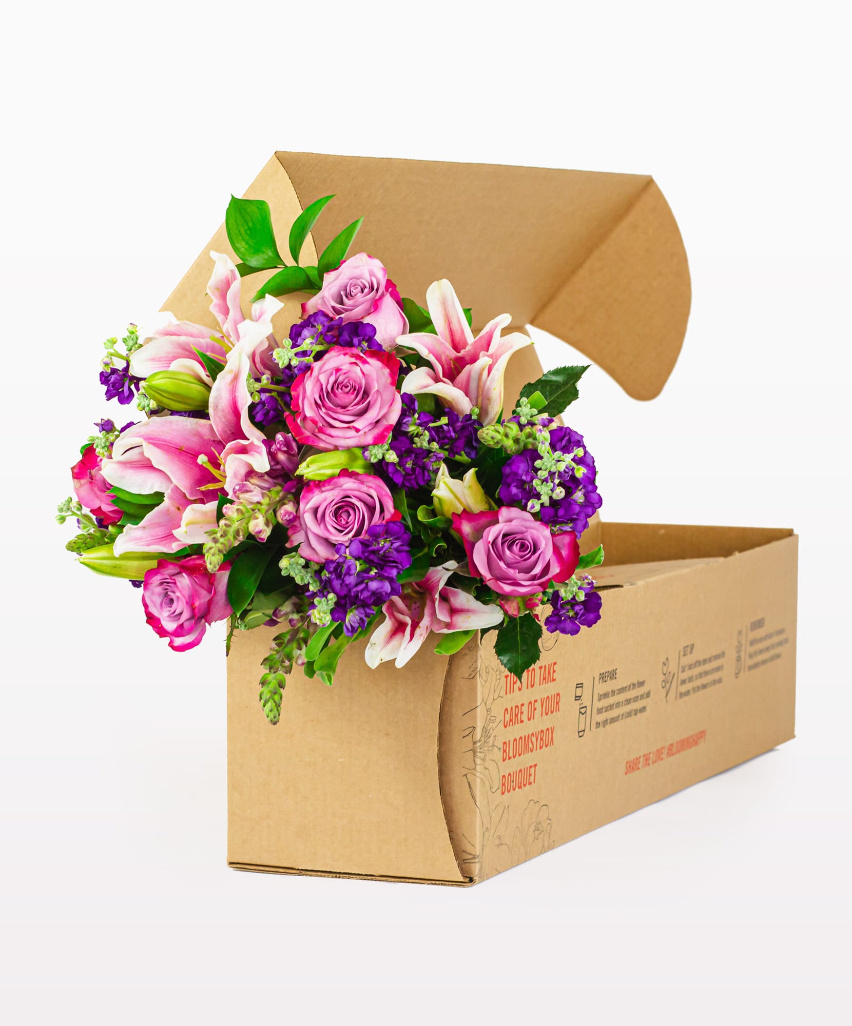 A vibrant bouquet featuring pink lilies, purple asters, and roses, elegantly packaged in a box.