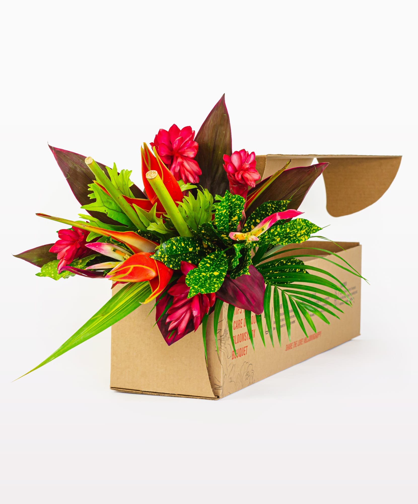 Vibrant tropical flower arrangement featuring bold reds and lush greens in a delivery box.
